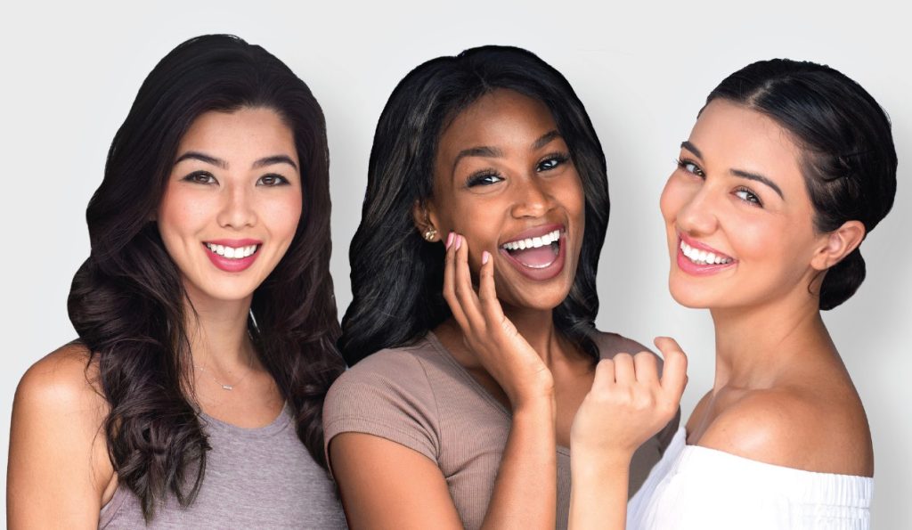 Three young, attractive women smiling and looking at camera