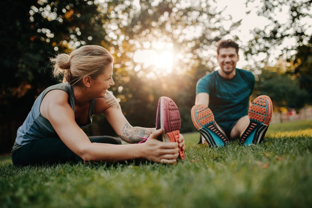 Couple stretching on grass